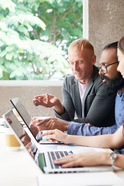 Designers configuring translation software dashboard on laptops for multilingual Pinterest